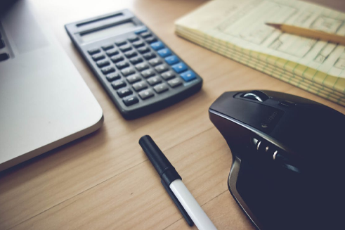 A modern desktop with a mouse and calculator - pawn shop services